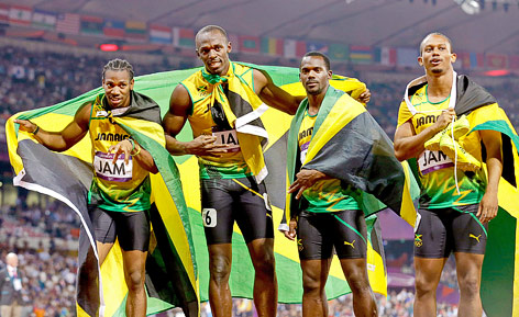 Jamaikas Yohan Blake, Usain Bolt, Nesta Carter und Michael Frater posieren mit der Nationalflagge