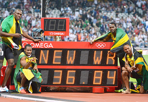 Usain Bolt, Yohan Blake, Nesta Carter and Michael Frater (alle JAM) stehen bei der Geschwindikeitsanzeige