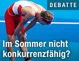Triathlet Andreas Giglmayr stützt sich erschöpft auf seinen Beinen ab